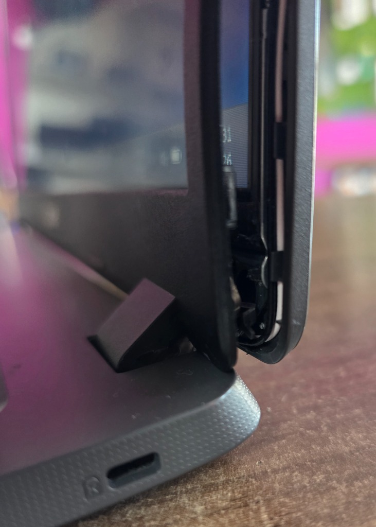 Notebook com dobradiça quebrada e carcaça aberta antes do reparo profissional na Info Fácil
